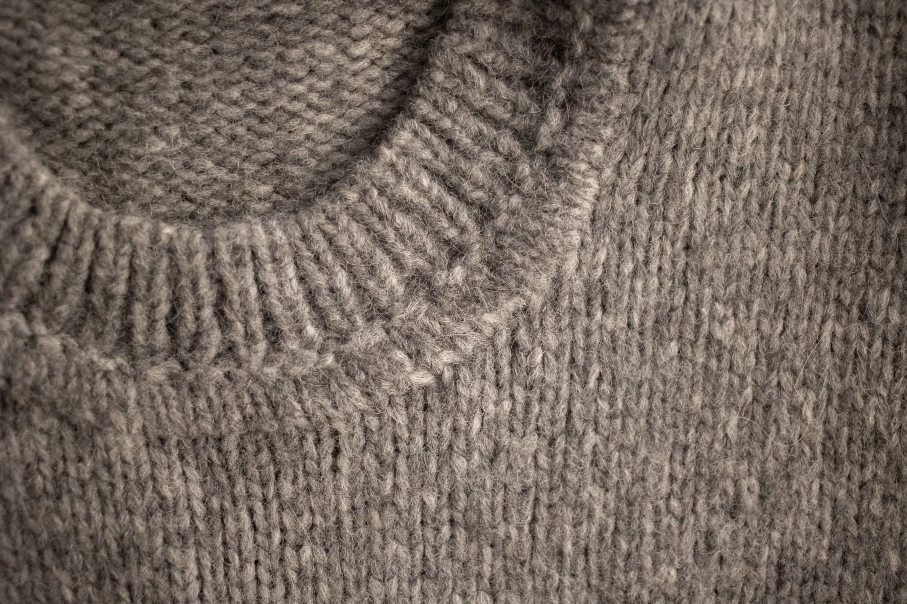 Close-up of a grey knitted jumper at the neckline