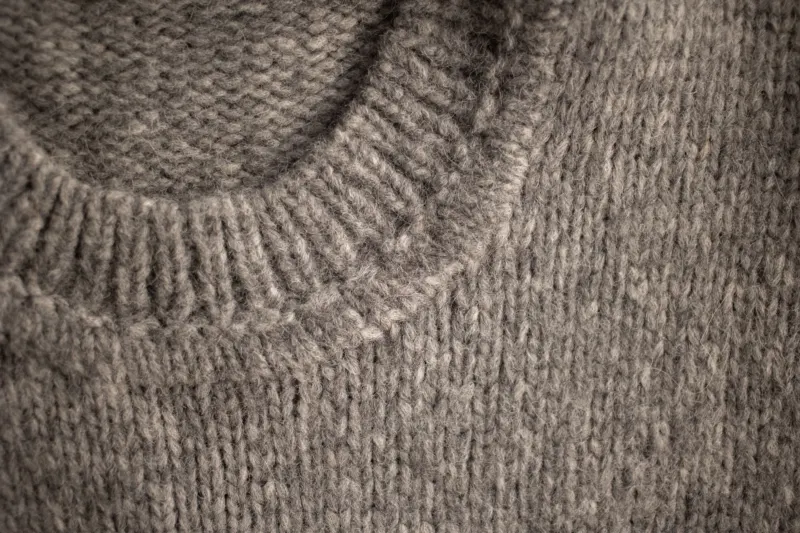 Close-up of a grey knitted jumper at the neckline